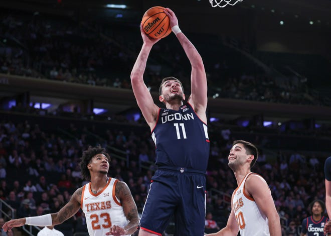 Connecticut forward Alex Karaban goes to the basket in front of Texas forwards Dillon Mitchell, left, and Brock Cunningham during the Empire Classic championship game at Madison Square Garden in New York City last November. According to reports, Texas will face back-to-back national champion UConn in a home-and-home series beginning this season at Moody Center in Austin.