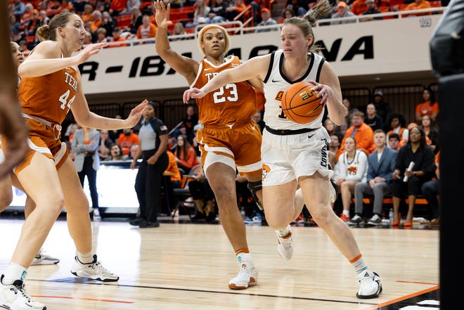 Jan 20, 2024; Stillwater, Okla, USA; Oklahoma State Cowgirls forward Lior Garzon (12) drives past Texas Longhorns forward Aaliyah Moore (23) in the second half of a womenÕs NCAA basketball game at Gallagher Iba Arena. Mandatory Credit: Mitch Alcala-The Oklahoman. Mandatory Credit: Mitch Alcala-The Oklahoman