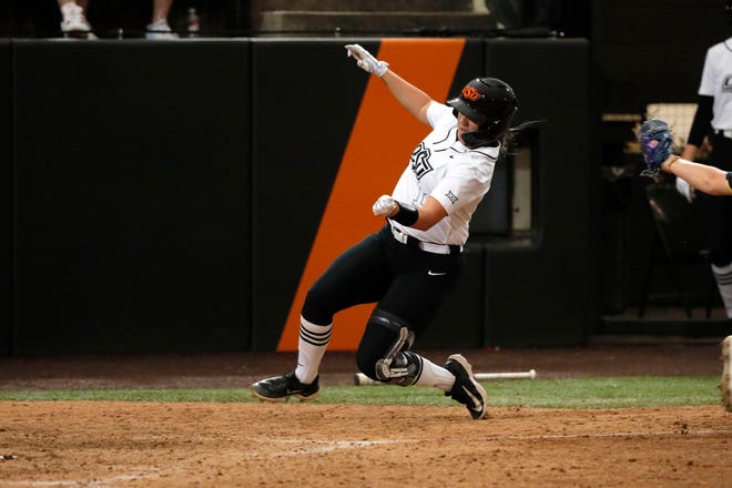 Oklahoma State infielder Micaela Wark (12) slides home to sore a run in the sixth inning of a college softball game between the Oklahoma State University Cowgirls and the South Dakota State Jackrabbits, Tuesday, Feb. 27, 2024.