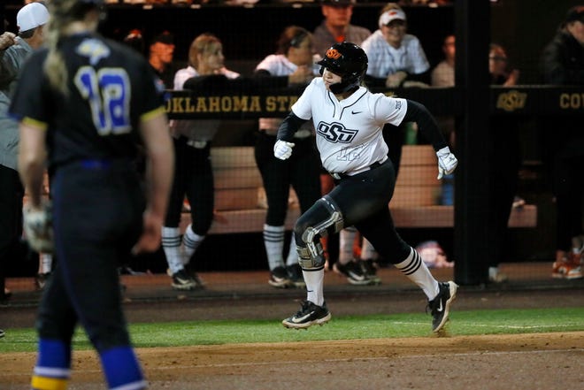 Oklahoma State infielder Micaela Wark (12) runs home to score a run in the second softball game of a double header between the Oklahoma State University Cowgirls and the South Dakota State Jackrabbits, Tuesday, Feb. 27, 2024.