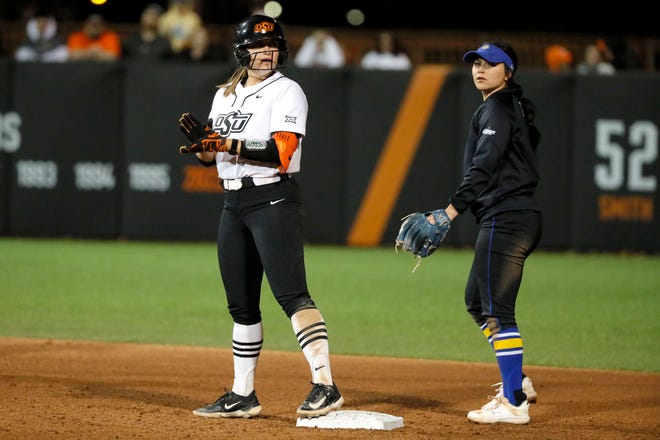 Oklahoma State catcher Caroline Wang (66) state ands on base next to South Dakota State infielder Rozelyn Carrillo (27) after driving in a run in the second softball game of a double header between the Oklahoma State University Cowgirls and the South Dakota State Jackrabbits, Tuesday, Feb. 27, 2024.