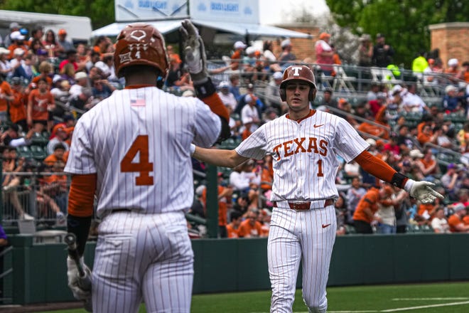 Texas infielder Jalin Flores, right, heads home after a home run during a game against Washington at UFCU Disch–Falk Field in March.