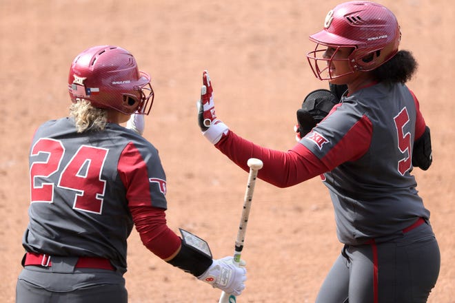 Oklahoma's Ella Parker (5) celebrates with Jayda Coleman (24) after driving in a run in the fourth inning during a college softball game between the University of Oklahoma Sooners (OU) and the Baylor Bears in Norman, Okla., Saturday, March 23, 2024.