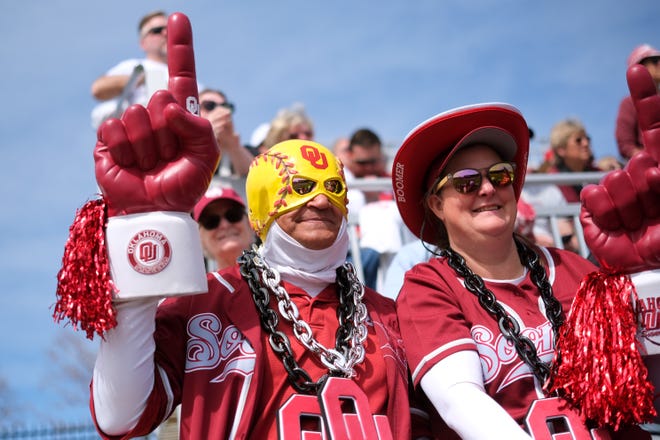 Oklahoma fans Rick and Jenny Trevino watch during a college softball game between the University of Oklahoma Sooners (OU) and the Baylor Bears in Norman, Okla., Saturday, March 23, 2024.