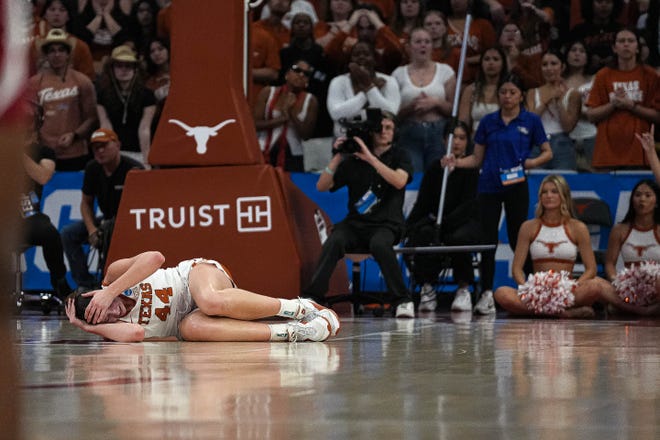Texas Longhorns forward Taylor Jones (44) holds her head after a fall during the NCAA playoff game against Alabama at the Moody Center on Sunday, Mar. 23, 2024 in Austin.