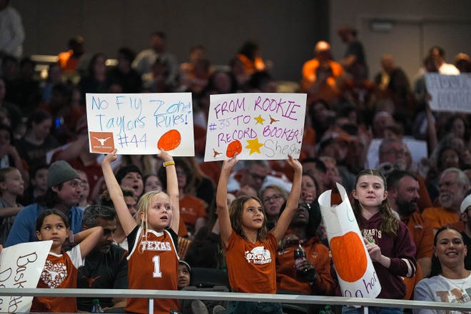 Texas Longhorns fans hold up signs during the NCAA playoff game against Alabama at the Moody Center on Sunday, Mar. 23, 2024 in Austin.
