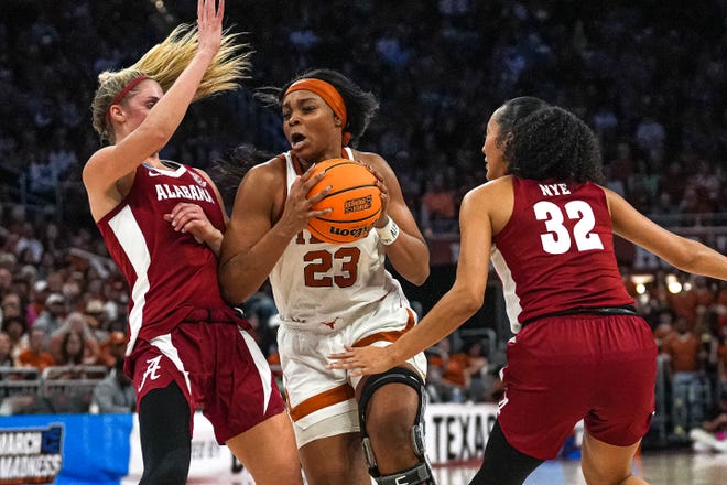 Texas Longhorns forward Aaliyah Moore (23) pushes past Alabama guards Sarah Barker (3) and Aaliyah Nye (32) during the NCAA playoff game at the Moody Center on Sunday, Mar. 23, 2024 in Austin.
