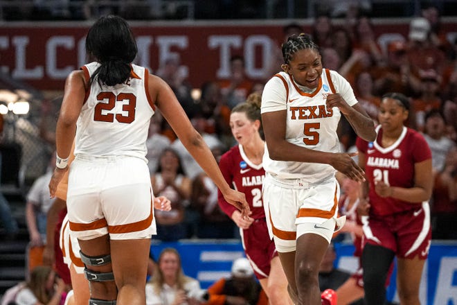Texas Longhorns forwards DeYona Gaston (5) and Aaliyah Moore (23) celebrate a score during the NCAA playoff game against Alabama at the Moody Center on Sunday, Mar. 23, 2024 in Austin.