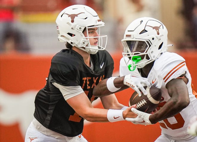 Texas Longhorns quarterback Arch Manning (16) hands the ball of to Texas White team running back Quintrevion Wisner (26) in the second quarter of the Longhorns' spring Orange and White game at Darrell K Royal Texas Memorial Stadium in Austin, Texas, April 20, 2024.