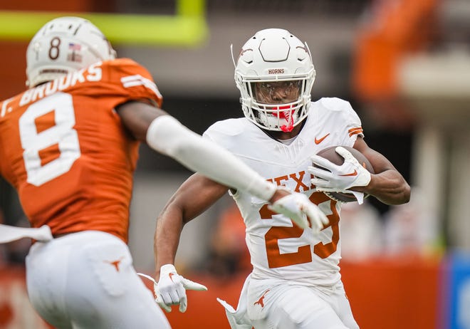Texas White team running back Jaydon Blue (23) carrie the ball while looking to evade defense from Texas Orange defensive back Terrance Brooks in the third quarter of the Longhorns' spring Orange and White game at Darrell K Royal Texas Memorial Stadium in Austin, Texas, April 20, 2024.