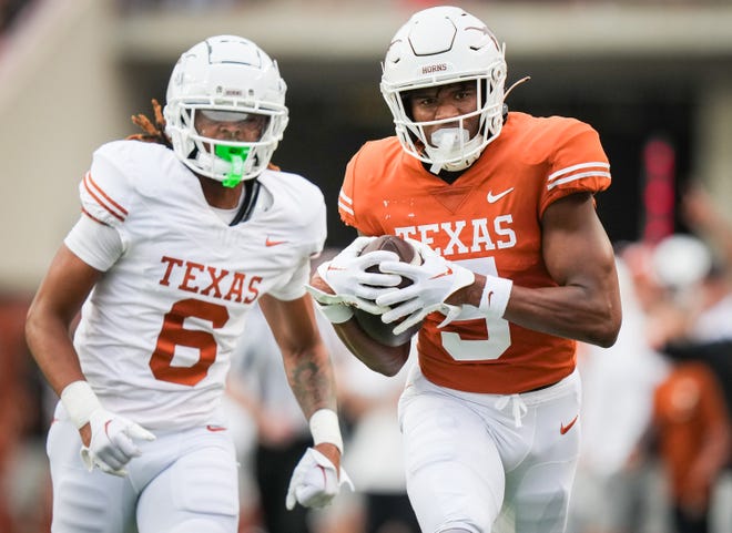 Texas Orange team wide receiver Ryan Wingo (5) carries the ball in for a touchdown as Texas White team defensive back Kobe Black (6) chases in the second quarter of the Longhorns' spring Orange and White game at Darrell K Royal Texas Memorial Stadium in Austin, Texas, April 20, 2024.