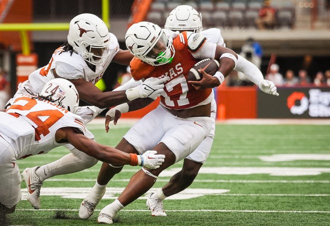 Texas Orange team running back Savion Red is tackled by three members of the Texas white team defense in the fourth quarter of the Longhorns' spring Orange and White game at Darrell K Royal Texas Memorial Stadium in Austin, Texas, April 20, 2024.