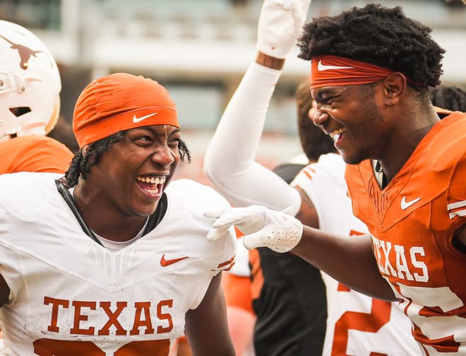 Texas Longhorns running back Ky Woods (29) celebrates with teammate defensive back Jelani McDonald (25) following the Longhorns' spring Orange and White game at Darrell K Royal Texas Memorial Stadium in Austin, Texas, April 20, 2024.