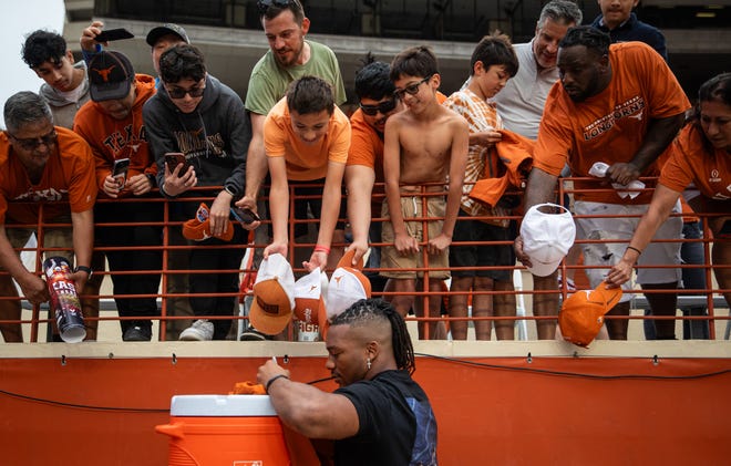 Former Texas Longhorn and current Atlanta Falcons running back Bijan Robinson signs autographs for fans while visiting for the Longhorns' spring Orange and White game at Darrell K Royal Texas Memorial Stadium in Austin, Texas, April 20, 2024.