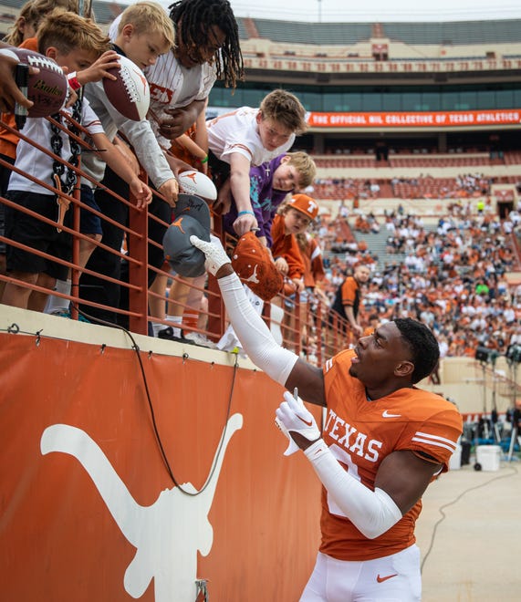 Texas Orange team defensive back Terrance Brooks (8) signs autographs for fans while visiting for the Longhorns' spring Orange and White game at Darrell K Royal Texas Memorial Stadium in Austin, Texas, April 20, 2024.