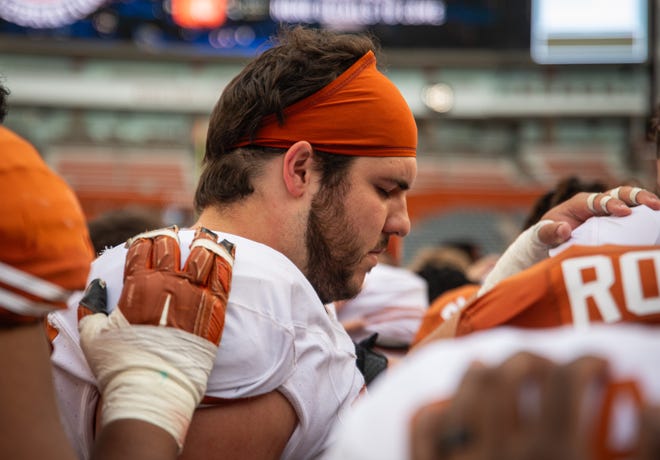 Texas White team offensive lineman Jake Majors (65) prays with the team following the Longhorns' spring Orange and White game at Darrell K Royal Texas Memorial Stadium in Austin, Texas, April 20, 2024.